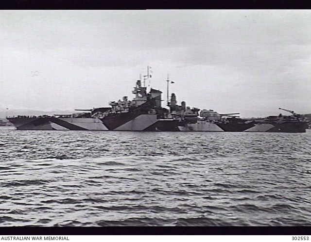 California after reconstruction following Pearl Harbor, with a tower superstructure and wartime camouflage. The archive does not give an exact photograph date; its credit strip is retained.