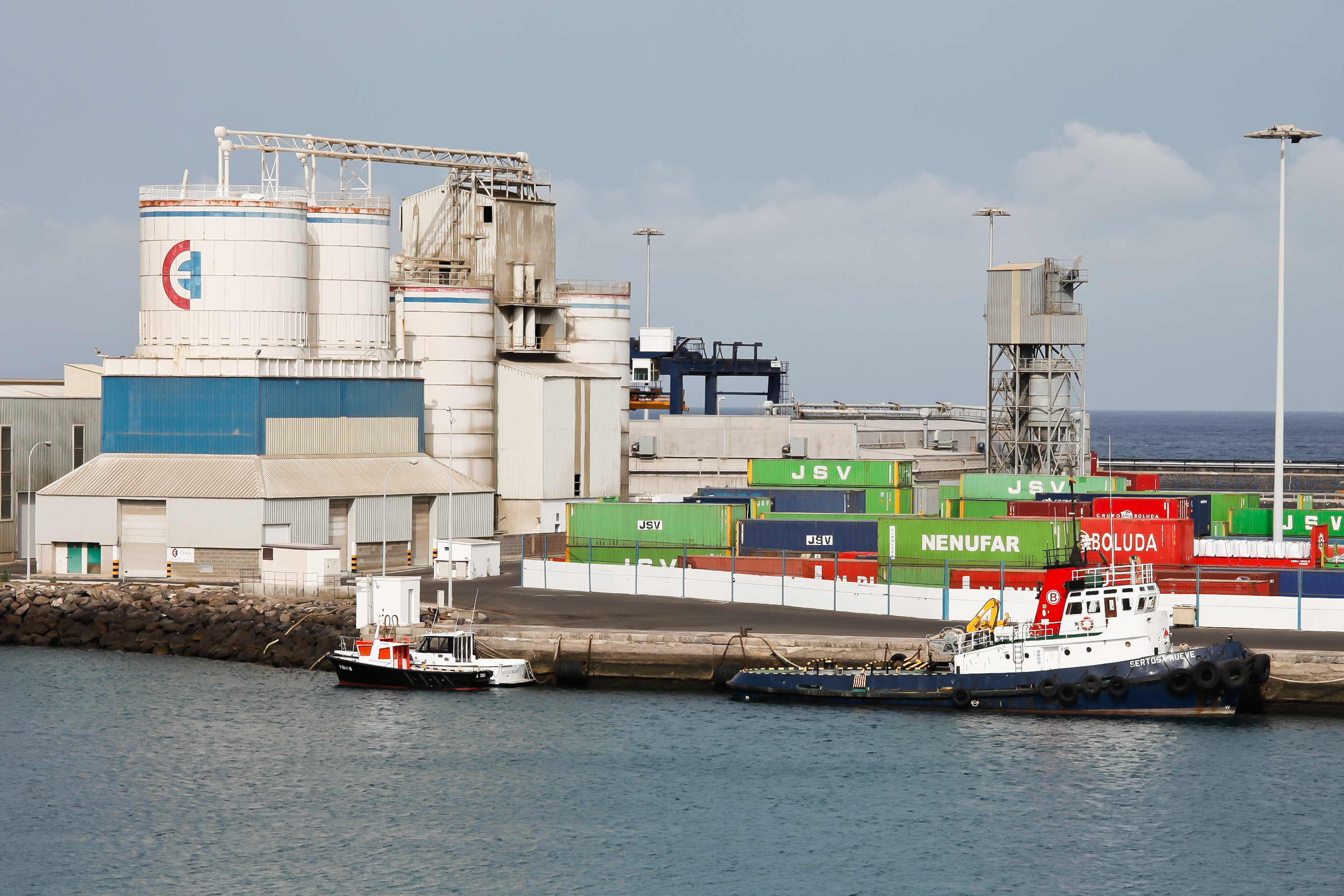 Tugboats alongside containers and industrial facilities in Arrecife harbour.